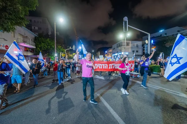 Hayfa, İsrail - 18 Ekim 2025: Çeşitli tabelaları ve bayrakları olan insanlar, ateşkes sonrasında hükümete karşı düzenlenen bir protesto mitingine katıldılar. Hayfa, İsrail