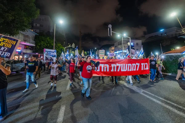 Hayfa, İsrail - 18 Ekim 2025: Çeşitli tabelaları ve bayrakları olan insanlar, ateşkes sonrasında hükümete karşı düzenlenen bir protesto mitingine katıldılar. Hayfa, İsrail