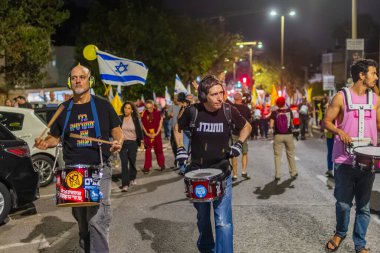 Hayfa, İsrail - 25 Ekim 2025: Çeşitli tabelaları ve bayrakları olan insanlar, ateşkes sonrasında hükümete karşı düzenlenen bir protesto mitingine katıldılar. Hayfa, İsrail