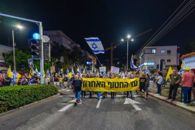 Hayfa, İsrail - 25 Ekim 2025: Çeşitli tabelaları ve bayrakları olan insanlar, ateşkes sonrasında hükümete karşı düzenlenen bir protesto mitingine katıldılar. Hayfa, İsrail