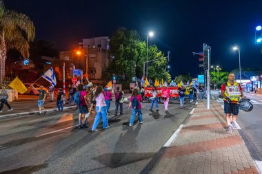 Hayfa, İsrail - 01 Kasım 2025: Çeşitli tabelaları ve bayrakları olan insanlar, ateşkes sonrasında hükümete karşı düzenlenen bir protesto mitingine katıldılar. Hayfa, İsrail