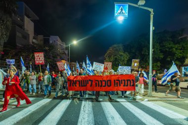Hayfa, İsrail - 08 Kasım 2025: Çeşitli tabela ve bayrakları olan insanlar, ateşkes sonrasında hükümete karşı düzenlenen bir protesto mitingine katıldılar. Hayfa, İsrail