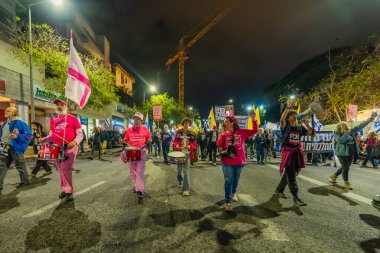 Hayfa, İsrail - 15 Kasım 2025: İnsanlar hükümete karşı yapılan ateşkesin ardından bir protesto yürüyüşüne (pembe cephe grubu) katılıyor. Hayfa, İsrail