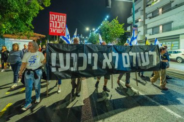 Hayfa, İsrail - 22 Kasım 2025: Çeşitli tabelaları ve bayrakları olan insanlar, ateşkes sonrasında hükümete karşı düzenlenen bir protesto mitingine katıldılar. Hayfa, İsrail