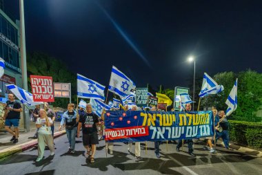 Hayfa, İsrail - 22 Kasım 2025: Çeşitli tabelaları ve bayrakları olan insanlar, ateşkes sonrasında hükümete karşı düzenlenen bir protesto mitingine katıldılar. Hayfa, İsrail