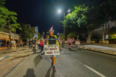 Hayfa, İsrail - 22 Kasım 2025: Çeşitli tabelaları ve bayrakları olan insanlar, ateşkes sonrasında hükümete karşı düzenlenen bir protesto mitingine katıldılar. Hayfa, İsrail