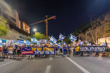 Hayfa, İsrail - 22 Kasım 2025: Çeşitli tabelaları ve bayrakları olan insanlar, ateşkes sonrasında hükümete karşı düzenlenen bir protesto mitingine katıldılar. Hayfa, İsrail