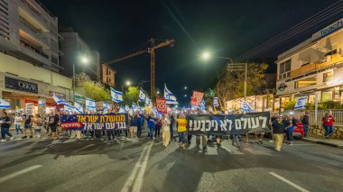 Hayfa, İsrail - 22 Kasım 2025: Çeşitli tabelaları ve bayrakları olan insanlar, ateşkes sonrasında hükümete karşı düzenlenen bir protesto mitingine katıldılar. Hayfa, İsrail