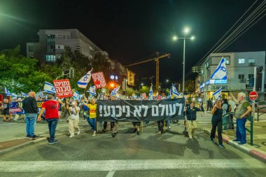 Hayfa, İsrail - 22 Kasım 2025: Çeşitli tabelaları ve bayrakları olan insanlar, ateşkes sonrasında hükümete karşı düzenlenen bir protesto mitingine katıldılar. Hayfa, İsrail