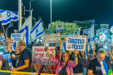 Hayfa, İsrail - 22 Kasım 2025: Çeşitli tabela ve bayraklara sahip bir grup insan, ateşkesin ardından hükümete karşı düzenlenen protestoya katıldı. Hayfa, İsrail