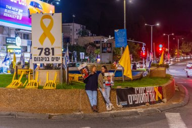 Hayfa, İsrail - 25 Kasım 2025: Tabela ve bayraklı insanlar, İsrail 'deki ateşkes anlaşmasının bir parçası olarak geri kalan son ölü rehinelerin de iade edilmesi çağrısında bulundular.