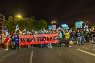 Hayfa, İsrail - 29 Kasım 2025: Çeşitli tabelaları ve bayrakları olan insanlar, ateşkes sonrasında hükümete karşı düzenlenen bir protesto mitingine katıldılar. Hayfa, İsrail