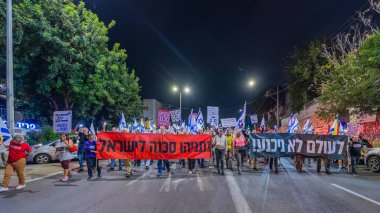 Hayfa, İsrail - 29 Kasım 2025: Çeşitli tabelaları ve bayrakları olan insanlar, ateşkes sonrasında hükümete karşı düzenlenen bir protesto mitingine katıldılar. Hayfa, İsrail