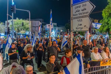 Hayfa, İsrail - 29 Kasım 2025: Çeşitli tabela ve bayraklara sahip bir grup insan, ateşkesin ardından hükümete karşı düzenlenen protestoya katıldı. Hayfa, İsrail