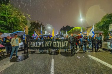 Hayfa, İsrail - 06 Aralık 2025: Çeşitli tabelaları ve bayrakları olan insanlar, ateşkes sonrasında hükümete karşı düzenlenen bir protesto mitingine katıldılar. Hayfa, İsrail