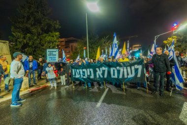Hayfa, İsrail - 06 Aralık 2025: Çeşitli tabelaları ve bayrakları olan insanlar, ateşkes sonrasında hükümete karşı düzenlenen bir protesto mitingine katıldılar. Hayfa, İsrail