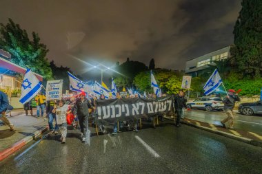 Hayfa, İsrail - 06 Aralık 2025: Çeşitli tabelaları ve bayrakları olan insanlar, ateşkes sonrasında hükümete karşı düzenlenen bir protesto mitingine katıldılar. Hayfa, İsrail