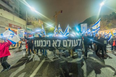 Hayfa, İsrail - 06 Aralık 2025: Çeşitli tabelaları ve bayrakları olan insanlar, ateşkes sonrasında hükümete karşı düzenlenen bir protesto mitingine katıldılar. Hayfa, İsrail