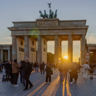 Berlin, Almanya - 03 Ekim 2025: Brandenburg Kapısı 'nın günbatımı manzarası, Berlin, Almanya' da yerel halk ve ziyaretçilerle