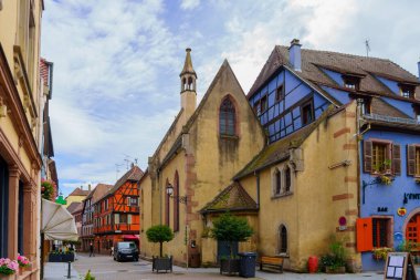 Ribeauville, Fransa - 30 Eylül 2024: Ribeauville, Haut-Rhin, Fransa 'da tipik evler, yerliler ve ziyaretçilerle dolu sokak sahnesi