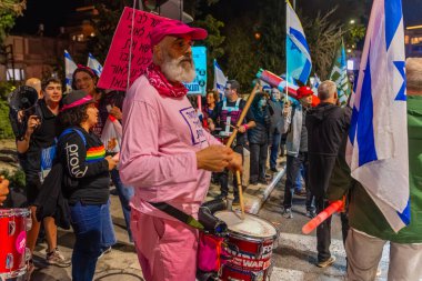 Hayfa, İsrail - 13 Aralık 2025: Çeşitli tabelaları ve bayrakları olan insanlar, hükümete karşı düzenlenen bir protesto mitingine katıldı, yeni polis gereksinimleri nedeniyle kaldırıma itildi. Hayfa, İsrail