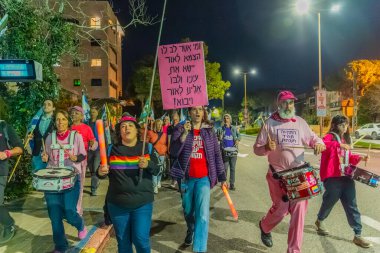 Hayfa, İsrail - 13 Aralık 2025: Çeşitli tabelaları ve bayrakları olan insanlar, hükümete karşı düzenlenen bir protesto mitingine katıldı, yeni polis gereksinimleri nedeniyle kaldırıma itildi. Hayfa, İsrail