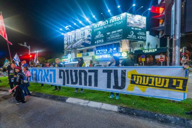 Hayfa, İsrail - 13 Aralık 2025: Çeşitli tabelaları ve bayrakları olan insanlar, ateşkes sonrasında hükümete karşı düzenlenen bir protesto mitingine katıldılar. Hayfa, İsrail