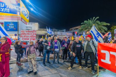 Hayfa, İsrail - 13 Aralık 2025: Çeşitli tabelaları ve bayrakları olan insanlar, ateşkes sonrasında hükümete karşı düzenlenen bir protesto mitingine katıldılar. Hayfa, İsrail