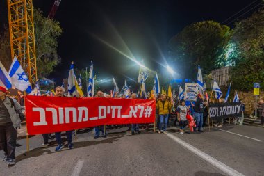 Hayfa, İsrail - 13 Aralık 2025: Çeşitli tabelaları ve bayrakları olan insanlar, ateşkes sonrasında hükümete karşı düzenlenen bir protesto mitingine katıldılar. Hayfa, İsrail