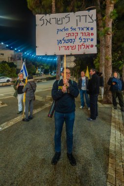 Hayfa, İsrail - 20 Aralık 2025: Çeşitli tabelaları ve bayrakları olan insanlar, ateşkes sonrasında hükümete karşı düzenlenen bir protesto mitingine katıldılar. Hayfa, İsrail