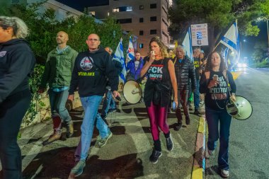 Hayfa, İsrail - 20 Aralık 2025: Çeşitli tabelaları ve bayrakları olan insanlar, hükümete karşı düzenlenen bir protesto mitingine katıldı, yeni polis gereksinimleri nedeniyle kaldırıma itildi. Hayfa, İsrail