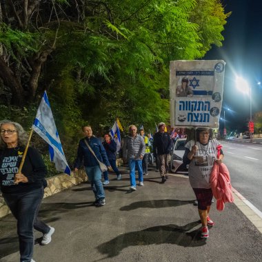 Hayfa, İsrail - 20 Aralık 2025: Çeşitli tabelaları ve bayrakları olan insanlar, hükümete karşı düzenlenen bir protesto mitingine katıldı, yeni polis gereksinimleri nedeniyle kaldırıma itildi. Hayfa, İsrail