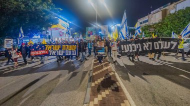 Hayfa, İsrail - 20 Aralık 2025: Çeşitli tabelaları ve bayrakları olan insanlar, ateşkes sonrasında hükümete karşı düzenlenen bir protesto mitingine katıldılar. Hayfa, İsrail