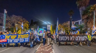 Hayfa, İsrail - 20 Aralık 2025: Çeşitli tabelaları ve bayrakları olan insanlar, ateşkes sonrasında hükümete karşı düzenlenen bir protesto mitingine katıldılar. Hayfa, İsrail
