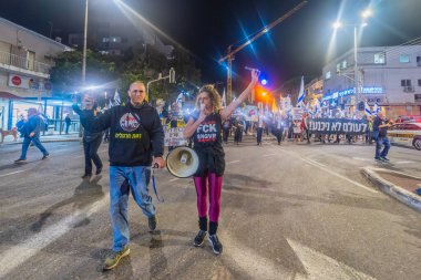 Hayfa, İsrail - 20 Aralık 2025: Çeşitli tabelaları ve bayrakları olan insanlar, ateşkes sonrasında hükümete karşı düzenlenen bir protesto mitingine katıldılar. Hayfa, İsrail