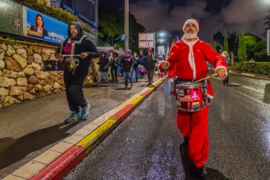 Hayfa, İsrail - 27 Aralık 2025: İnsanlar hükümete karşı bir protesto yürüyüşüne (Noel Baba gibi giyinmiş bir adamla birlikte) katılıyor. Hayfa, İsrail