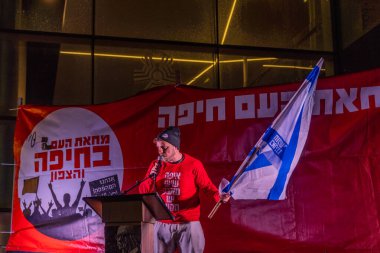 Hayfa, İsrail - 27 Aralık 2025: Çeşitli tabela ve bayraklara sahip bir kalabalık hükümete karşı düzenlenen bir protesto mitingine katıldı. Hayfa, İsrail