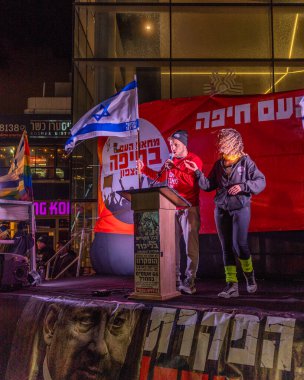 Hayfa, İsrail - 27 Aralık 2025: Çeşitli tabela ve bayraklara sahip bir kalabalık hükümete karşı düzenlenen bir protesto mitingine katıldı. Hayfa, İsrail