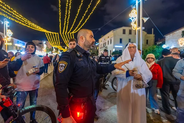 Hayfa, İsrail - 31 Aralık 2025: Katar Kapısı yolsuzluk olayının sembolik bir protestosu olarak Katar Şeyhleri gibi giyinmiş bir grup eylemciyle polis karşı karşıya geldi. Alman Kolonisi, Hayfa, İsrail