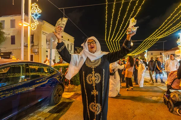 Hayfa, İsrail - 31 Aralık 2025: Katar Şeyhi gibi giyinmiş bir grup aktivist, Katar-kapısı yolsuzluk olayının sembolik bir protestosu olarak insanlara para dağıtıyor. Alman Kolonisi, Hayfa, İsrail