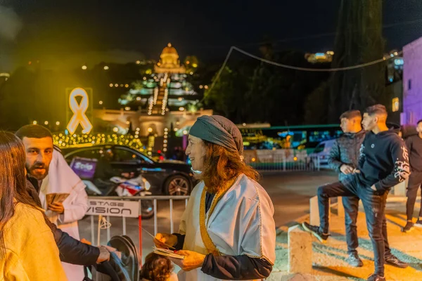 Hayfa, İsrail - 31 Aralık 2025: Katar Şeyhi gibi giyinmiş bir grup aktivist, Katar-kapısı yolsuzluk olayının sembolik bir protestosu olarak insanlara para dağıtıyor. Alman Kolonisi, Hayfa, İsrail