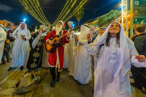 Hayfa, İsrail - 31 Aralık 2025: Katar Şeyhi gibi giyinmiş bir grup aktivist, Katar-kapısı yolsuzluk olayının sembolik bir protestosu olarak insanlara para dağıtıyor. Alman Kolonisi, Hayfa, İsrail