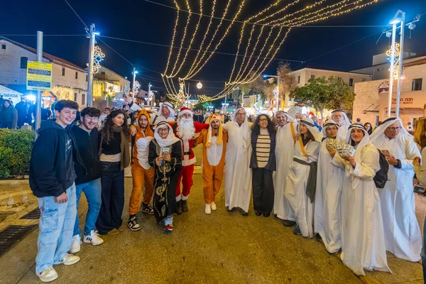 Hayfa, İsrail - 31 Aralık 2025: Katar Şeyhi gibi giyinmiş bir grup aktivist, Katar-kapısı yolsuzluk olayının sembolik bir protestosu olarak insanlara para dağıtıyor. Alman Kolonisi, Hayfa, İsrail