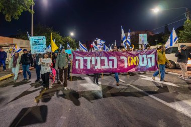 Hayfa, İsrail - 3 Ocak 2026: Çeşitli tabelaları ve bayrakları olan insanlar hükümete karşı düzenlenen bir protesto mitingine katıldılar. Hayfa, İsrail