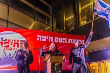 Hayfa, İsrail - 3 Ocak 2026: Çeşitli tabela ve bayraklara sahip bir kalabalık hükümete karşı düzenlenen bir protesto mitingine katıldı. Hayfa, İsrail