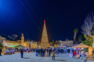 Nasıra, İsrail - 06 Ocak 2026: Kilisenin (Mary well) Ortodoks Noel arifesi meydanı, Yunan Ortodoks Annunciation Kilisesi, Noel ağacı ve kalabalık, Nasıra, İsrail