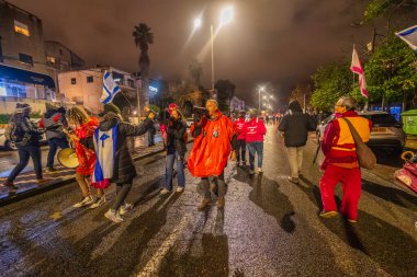 Hayfa, İsrail - 10 Ocak 2026: Çeşitli tabelaları ve bayrakları olan insanlar hükümete karşı düzenlenen bir protesto mitingine katıldılar. Hayfa, İsrail
