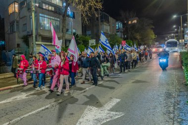 Hayfa, İsrail - 14 Şubat 2026: Çeşitli tabelaları ve bayrakları olan insanlar hükümete karşı düzenlenen bir protesto mitingine katıldılar. Hayfa, İsrail