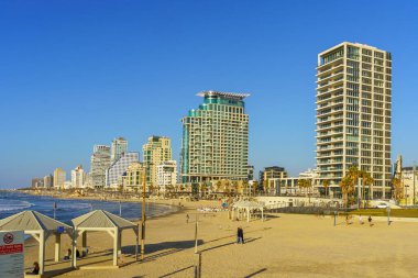 Tel Aviv, İsrail - 25 Şubat 2026: Yerel halk ve ziyaretçilerin olduğu plaj sahnesi ve şehir silüeti. Tel-Aviv, İsrail