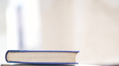 Sol tarafta parlak arka planı ve doğal ışığı olan eski mavi bir kitap var.